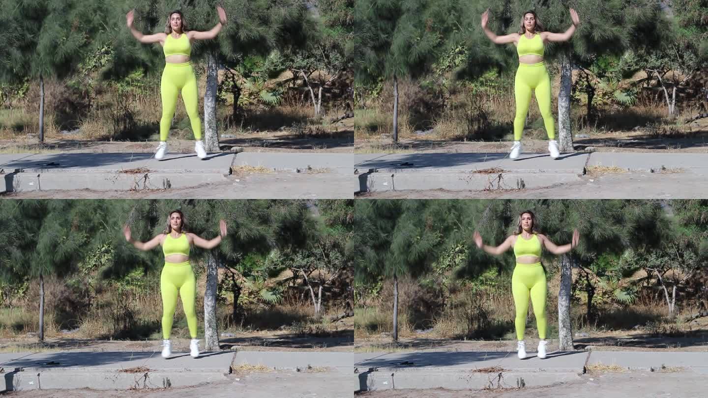 公园里健身的女人穿着运动服做开合跳。运动型拉丁模型