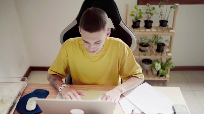年轻人在家里用笔记本电脑工作