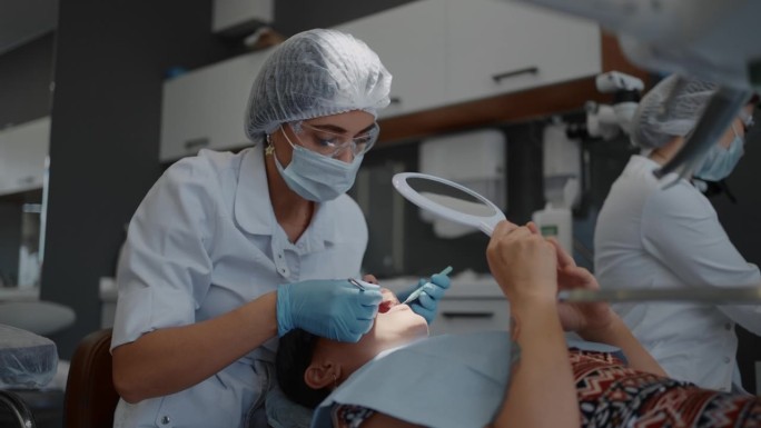 现代牙科美容与正畸临床，女医生检查病人牙齿
