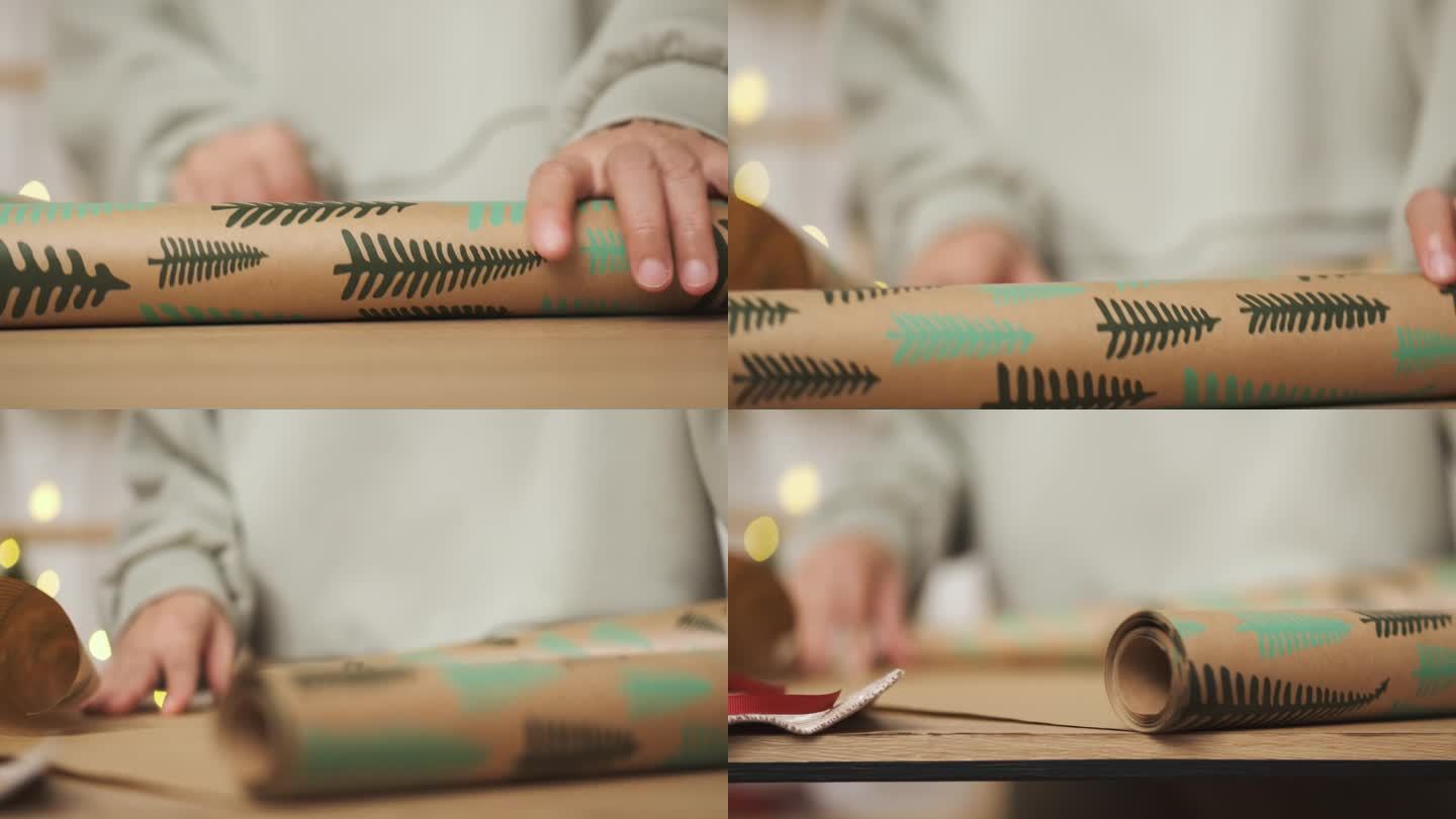 近距离手在桌子上卷圣诞包装纸。为新年节日准备礼物。
