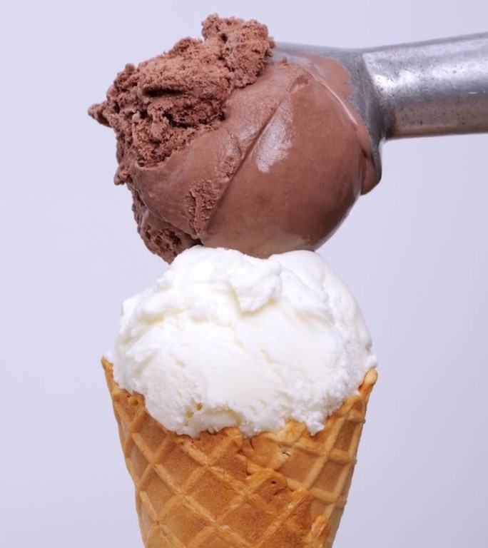 一勺巧克力冰淇淋放在椰奶冰淇淋的上面。