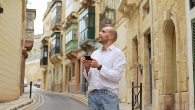 在马耳他的Cospicua，年轻的男游客正在用智能手机查找路线