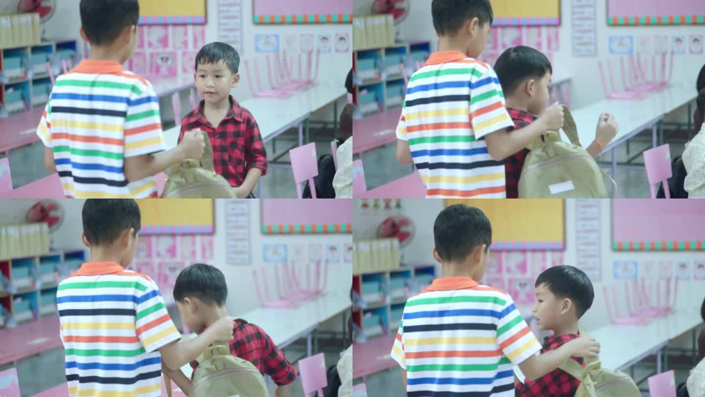 亚裔哥哥在教室里给了弟弟一个背包。