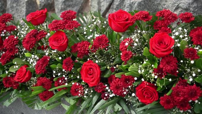 红色的花朵与绿色的刺绣组成，美丽的花束，雏菊和玫瑰