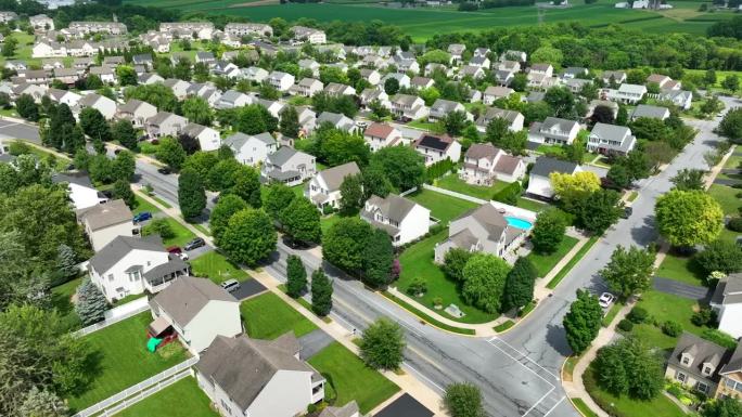 大的美国社区的广角镜头，满是家庭住宅和住宅。成熟的树木和草在夏天。美国社区住房发展的美丽航拍照片。
