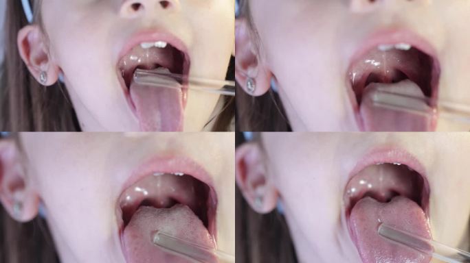 勇敢开朗的女孩向医生张大嘴巴，露出喉咙。