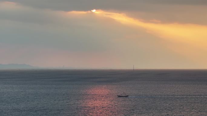 航拍威海小石岛西侧海面上的落日余晖与渔船