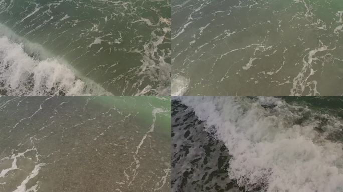 平滑的电影架空，海浪在浅水中撞击卵石海滩。在菲律宾拍摄。