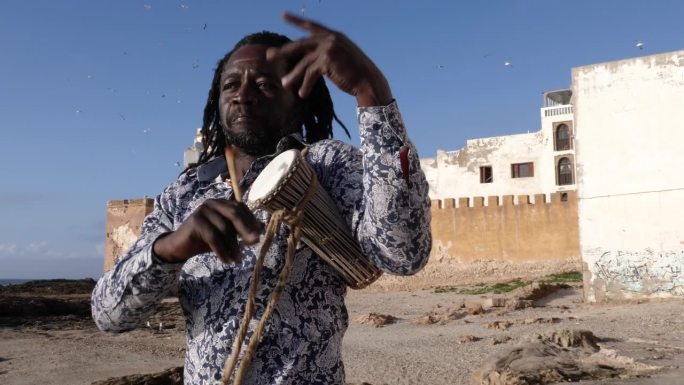 非洲打击乐，一名塞内加尔男子用棍子演奏传统的小dunun鼓。