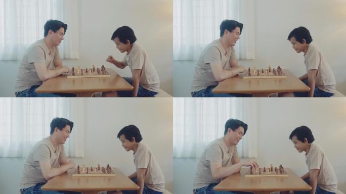 周到英俊的亚洲父亲和可爱的儿子在下棋，而周末家人在家里的房间里休闲和亲密。