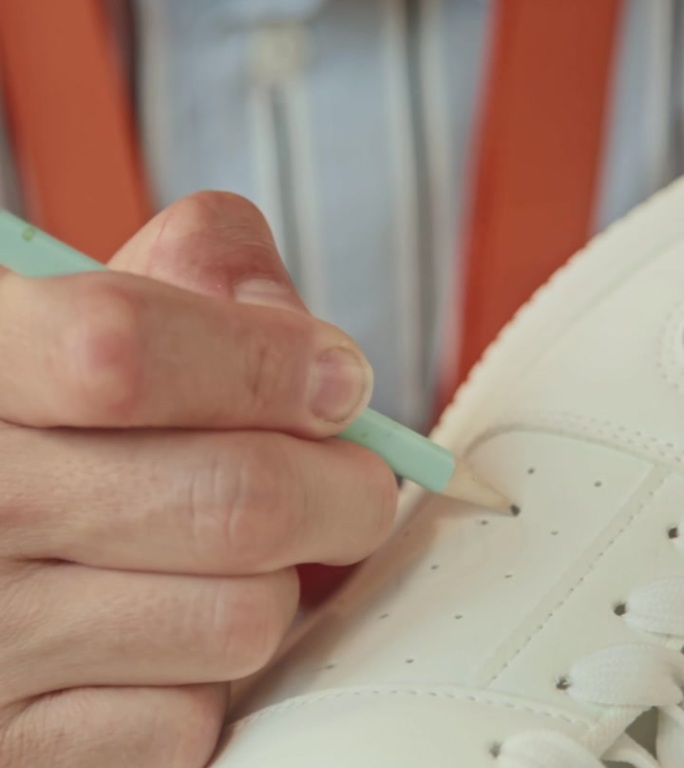 男艺术家在运动鞋上绘制草图以供定制