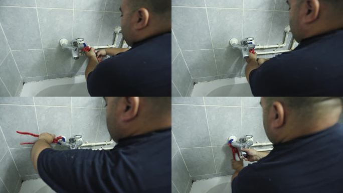 白人男性水管工在修理浴室水龙头时用钳子