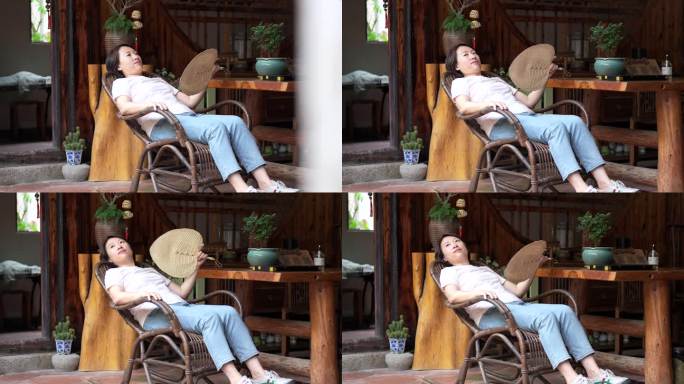 4K升格坐在中式庭院躺椅摇椅上休息的女人