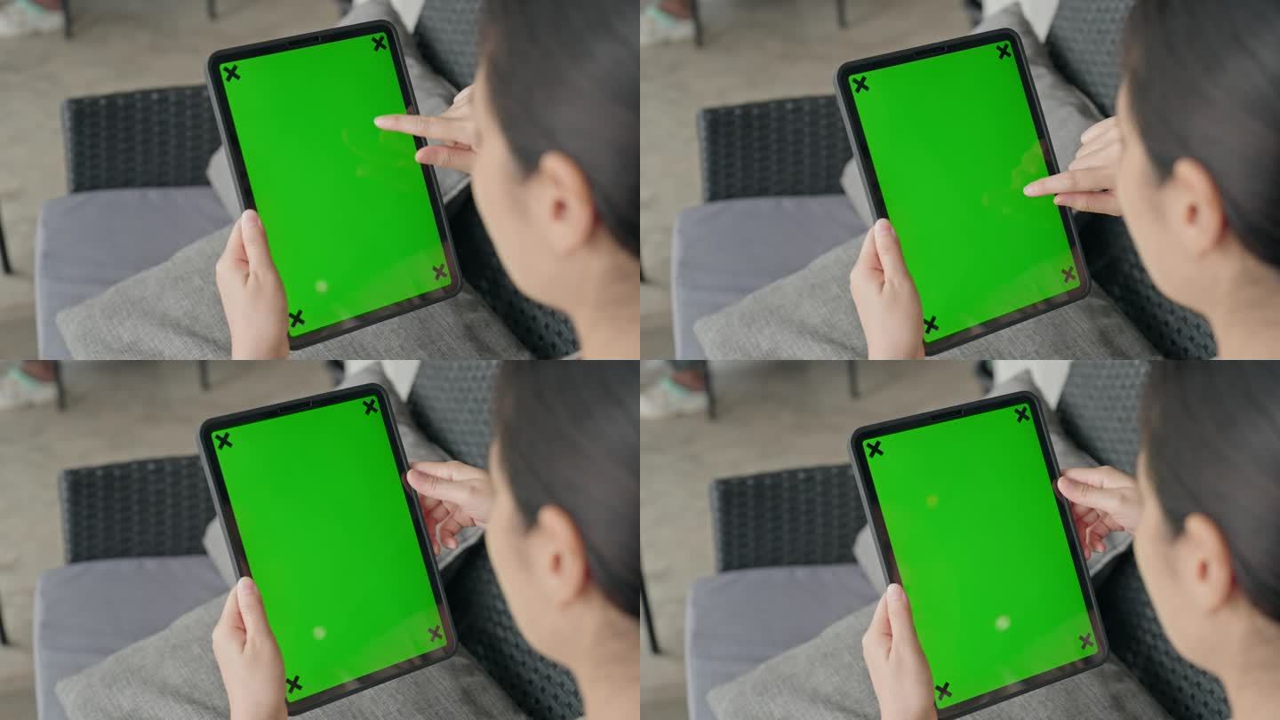 使用绿屏数码平板电脑的妇女