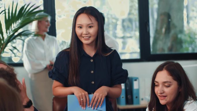 有吸引力的年轻亚洲女性团队领导在轻松的办公室里倾听和交谈快乐和积极的同事