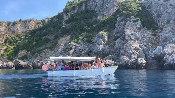 乘船游览附近的科孚岛景点深干净清澈的水山自然泉水乘船过往的人游客和旅客