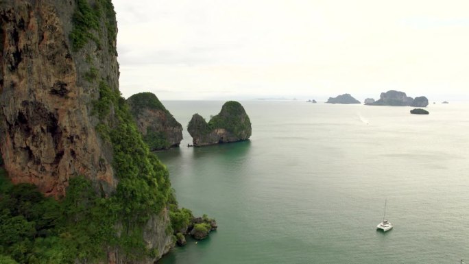 莱利的蝙蝠洞与高大的岩石石灰岩悬崖和热带岛屿的海洋景观在地平线上从空中无人机。