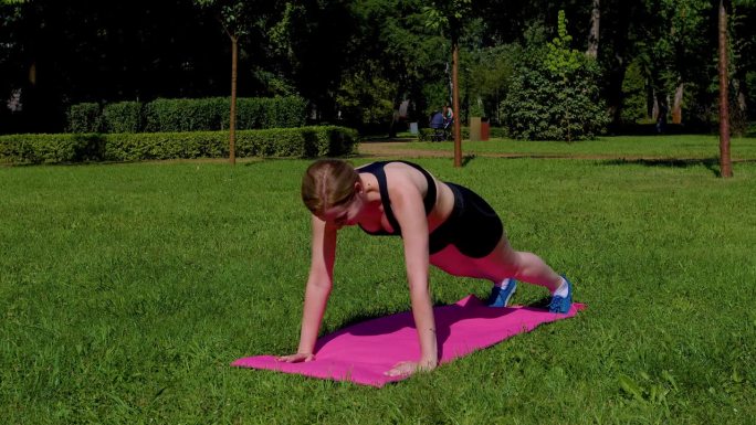 意志坚定的运动健体女性在大自然中练习俯卧撑