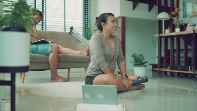 机器人真空吸尘器:亚洲残疾夫妇在家锻炼，营造整洁的环境