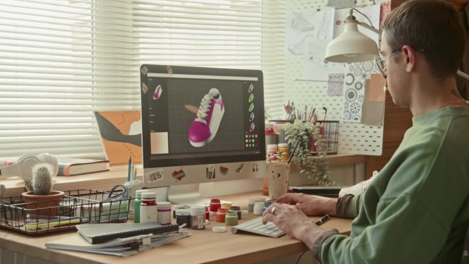 男设计师在3D程序中选择运动鞋颜色
