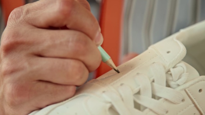 男创意设计师在白色运动鞋上作画
