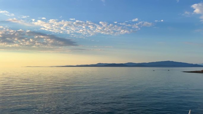 背景广告旅行到大海或海洋只有天空和水的地平线浅蓝色的海洋和黄色的日落自然山脉可见在远处空框为文字