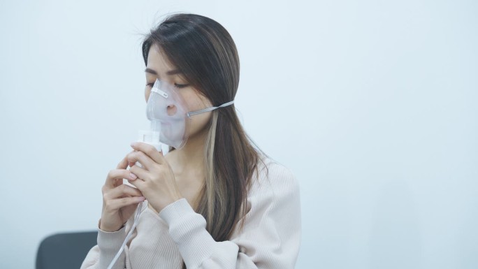 患有哮喘的亚洲华裔中年妇女正在吸氧