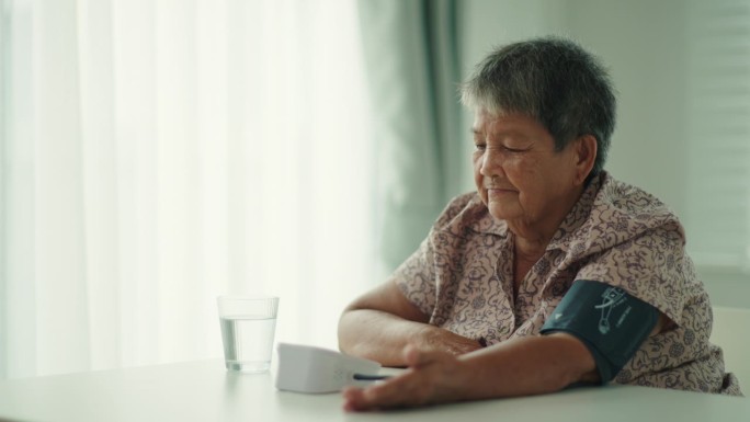 一位老妇人正在家里自己检查血压和心率。