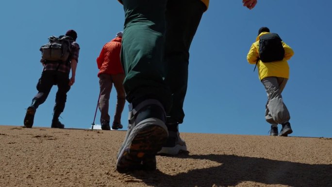 旅游团在沙漠地区慢动作。游客的脚步渐近
