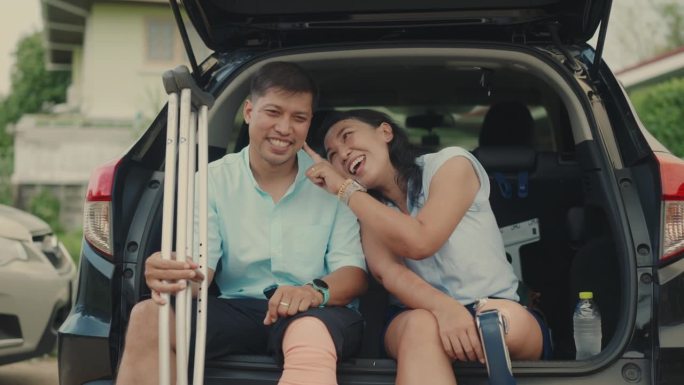 亚洲残障夫妇在汽车后备箱享受美好时光-包容与爱