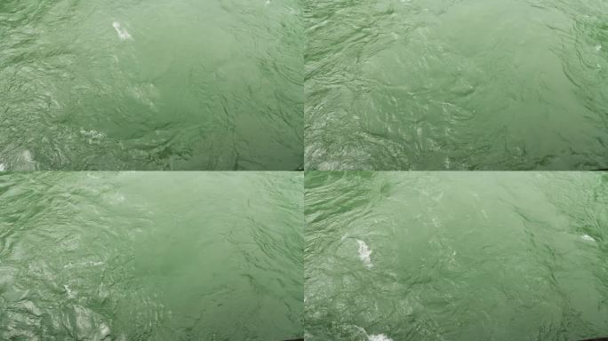 从上面看河。视频作为背景。高角度看绿色的水和波浪。平静的海浪和水，4k慢动作镜头。