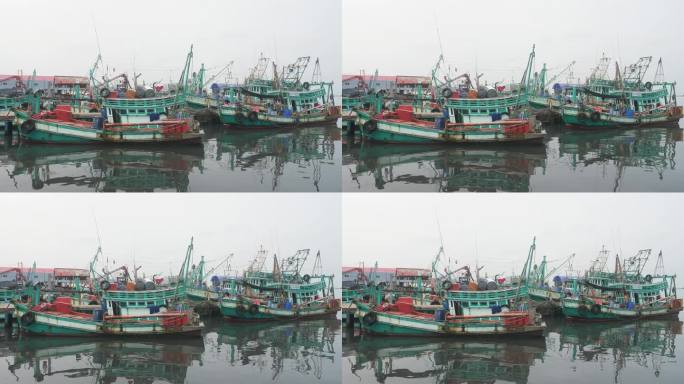 停泊在海上渔港的渔船的倒影在水面上荡起涟漪
