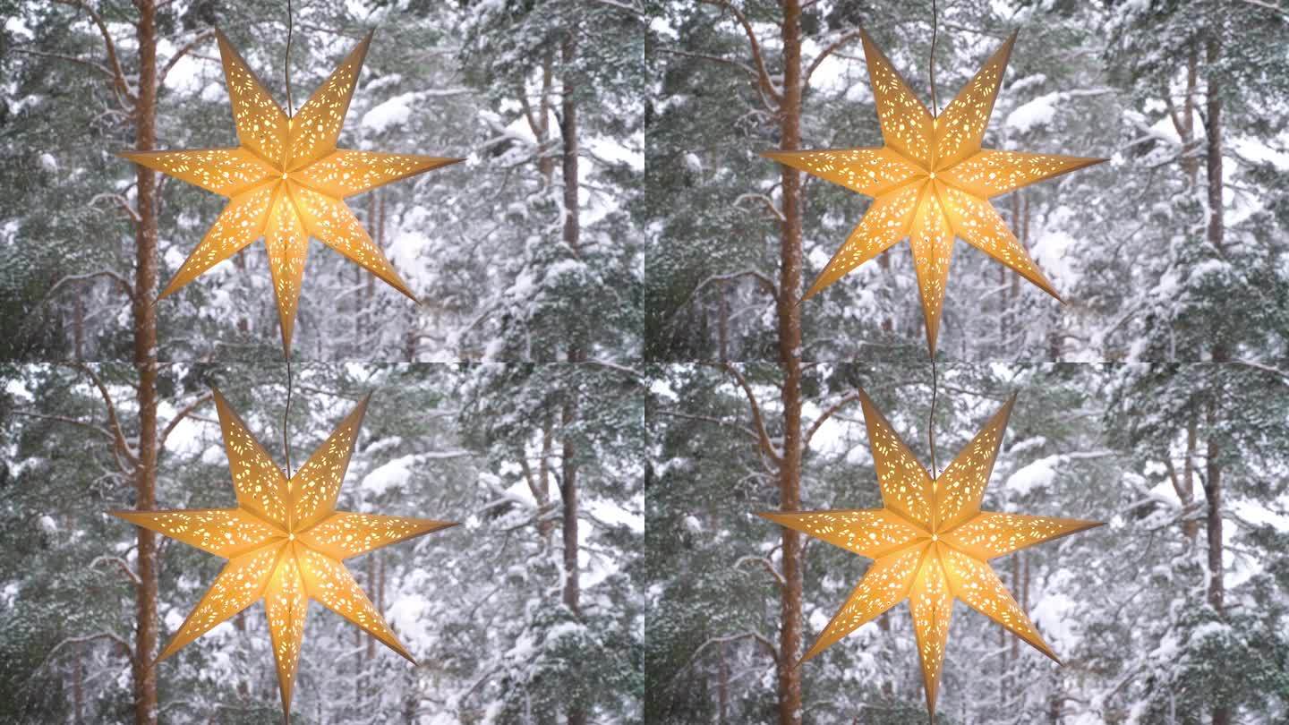 窗户上装饰的圣诞星星，背景是冬天的森林