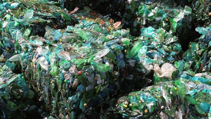 多个立方体压缩绿色塑料垃圾在废物回收工厂在露天