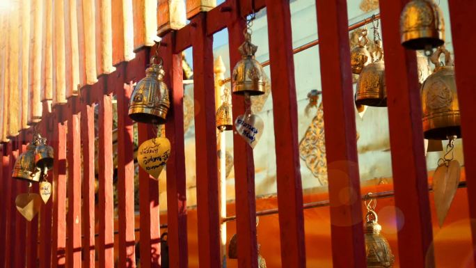 在泰国清迈的素贴寺，佛教徒在阳光下将他们的愿望写在金钟上，挂在寺庙的栅栏上。清迈著名的旅游景点景点地
