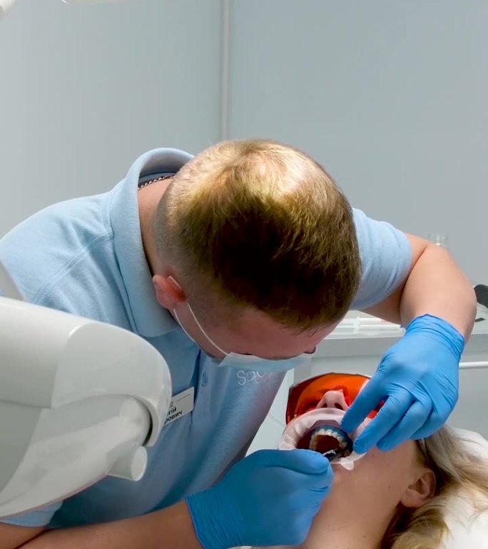 牙科治疗在牙科诊所使用液体橡胶坝防光聚合物灯眼镜护士和医生病人真人诚实无菌病人护理手术口扩张器