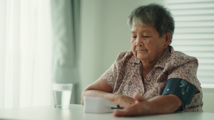 一位老妇人正在家里自己检查血压和心率。
