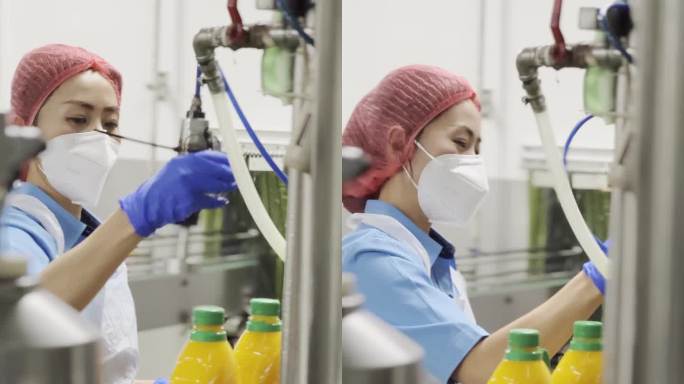 亚裔华裔果汁工厂女工在生产线上给橙汁封盖