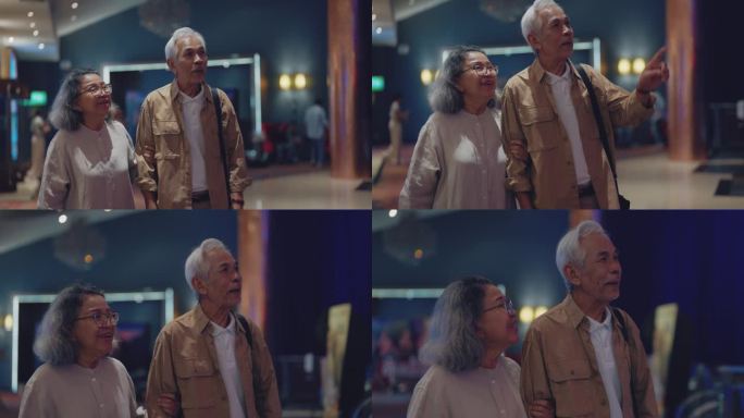 一位年长的女士和一位男士手挽着手一起走进电影院。