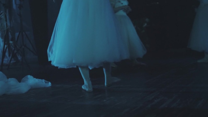 一位芭蕾舞女演员在舞台上伸展她的双腿。芭蕾舞演员正在为演出做准备。专业的芭蕾舞。