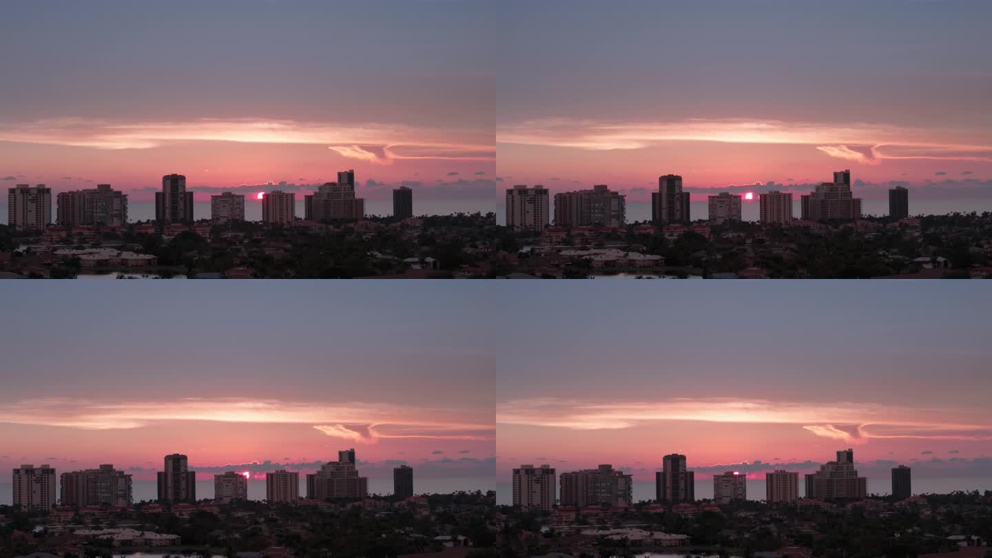 橙色的夕阳和佛罗里达那不勒斯海岸高层建筑的剪影。航拍变焦照片