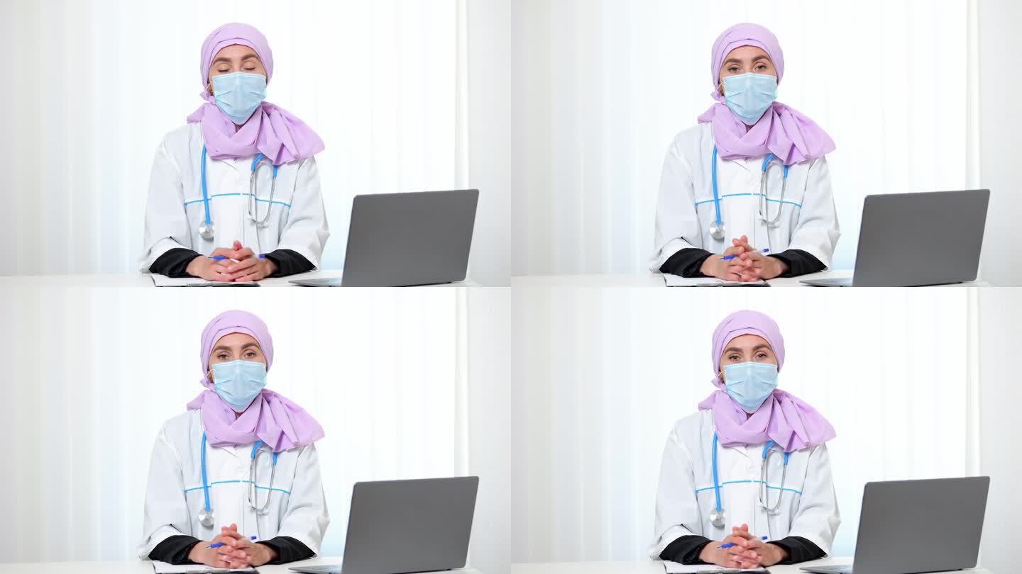 戴口罩的穆斯林医生坐在私人诊所办公室里
