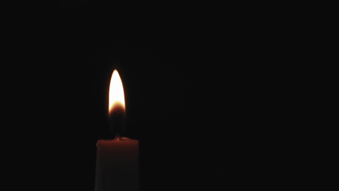在黑暗中用另一支蜡烛点燃一支蜡烛的慢动作