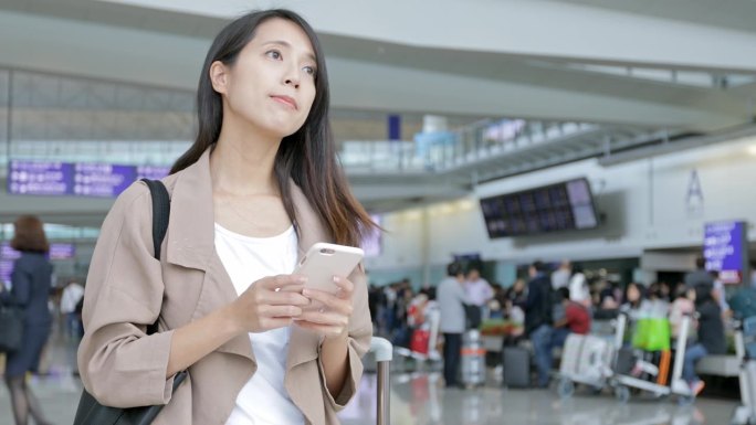 女子在香港国际机场用手机发短讯