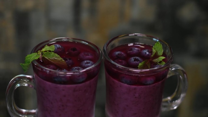 桌上有鲜榨的蓝莓汁。两杯健康的夏日饮品。