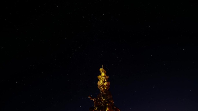 夏夜峨眉山金色普仙佛像前景的移动星星4k延时镜头。