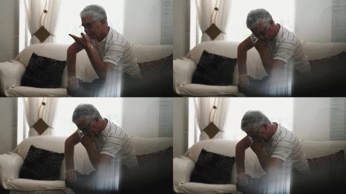 经历挫折和烦恼的老人，独自在家拍偷拍的场景，坐在沙发上静静地沉思