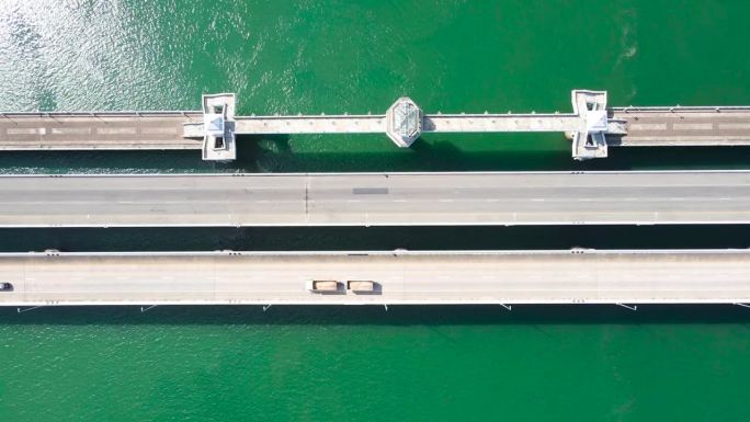 航拍视频无人机飞过桥梁道路上的海俯视视图