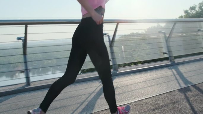 穿着皮制打底裤的女性腿在桥上疾跑