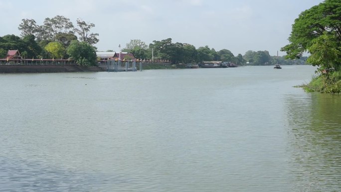 阳光明媚的河面，以乡村小镇为背景，慢动作场景